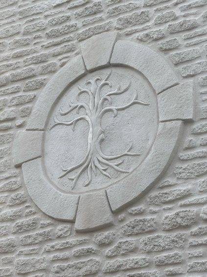 Rénovation d'un mur avec enduit à la chaux imitation pierres ou parement, avec dessin d'un arbre sculpté près de Fontainebleau